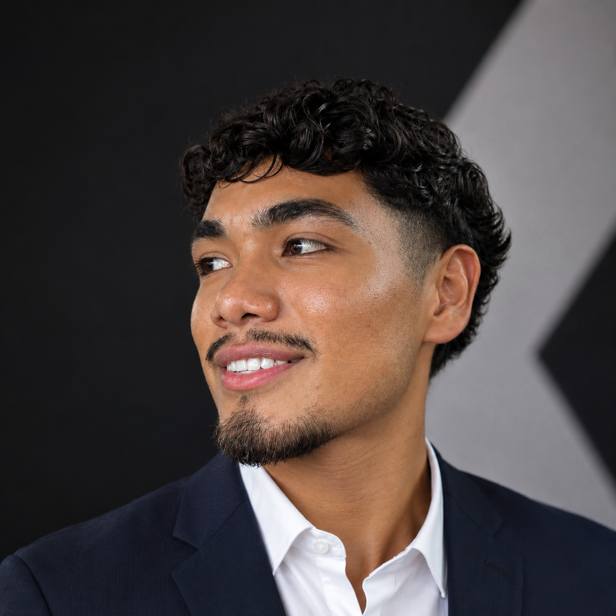 Eder Solis, founder of Envisage AI, in a dark suit against an angled backdrop